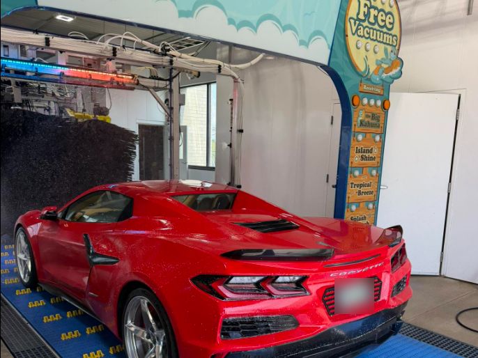 Freshly washed red sports car leaving the Ohana Car Wash tunnel